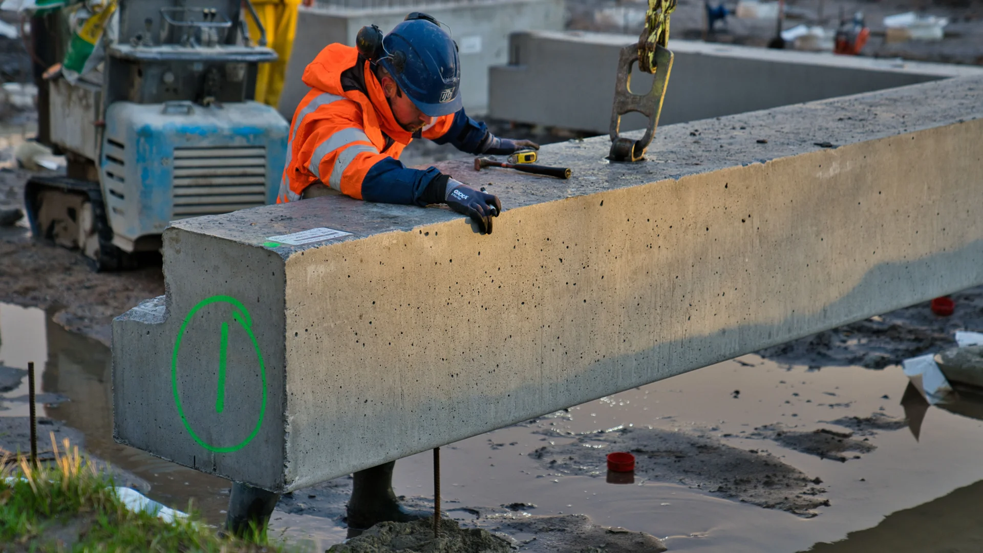Een IJB medewerker bij een betonnen funderingselement